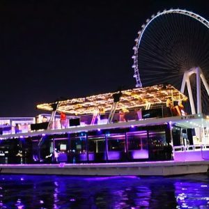 Ain Dubai houseboat cruising near Dubai Marina, offering stunning views of the world’s largest Ferris wheel. Tickets available through El Camino Travel