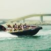 black boat cruising through Dubai’s waters, showcasing iconic landmarks like Burj Al Arab and Palm Jumeirah, booked through El Camino Travel Dubai